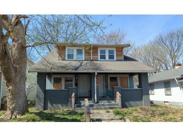Charming duplex home with a covered front porch and well-maintained front yard and mature trees in the yard at 822 N Bradley Ave, Indianapolis, IN 46201