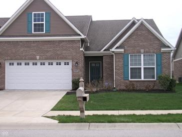 Charming brick home featuring a two-car garage and well-maintained front yard at 8801 Twain Ln, Indianapolis, IN 46239