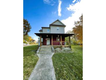 Charming two-story home with a welcoming front porch and well-maintained lawn, perfect for enjoying outdoor living at 905 W 3Rd St, Anderson, IN 46016