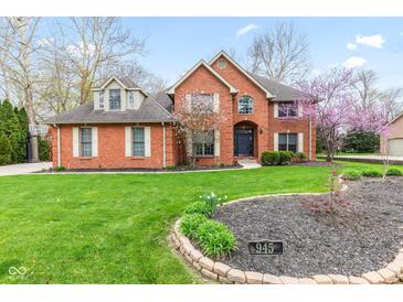 Charming brick home with a manicured lawn, blossoming tree, and welcoming curb appeal at 945 Baywood Ct, Columbus, IN 47201