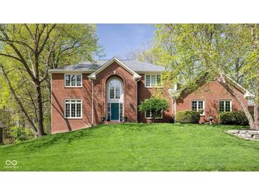 Charming brick home featuring a well-manicured lawn and lush trees, enhancing its curb appeal at 9838 Gulfstream Ct, Fishers, IN 46037