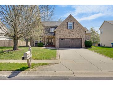Beautiful two-story brick home featuring an attached garage and manicured front yard, offering timeless appeal at 11347 Whitewater Way, Fishers, IN 46037