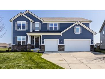 Charming two-story home with a two-car garage, beautiful blue siding and a well-manicured front lawn at 11880 Whisper Ridge Dr, Noblesville, IN 46060