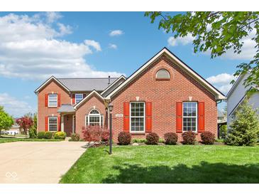 Charming brick home with red shutters and manicured lawn under a blue sky, offering classic curb appeal at 12088 Everwood Cir, Noblesville, IN 46060