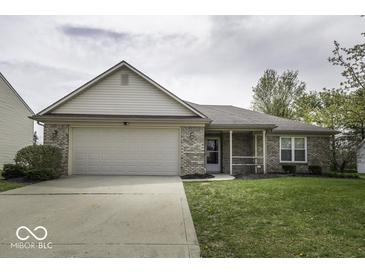 Charming single-story home with a well-manicured lawn and attached two-car garage at 12249 E Harvest Glen Dr, Cumberland, IN 46229