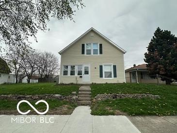 Charming two-story home with a well-manicured front yard, set back from the street at 137 S 2Nd Ave, Beech Grove, IN 46107
