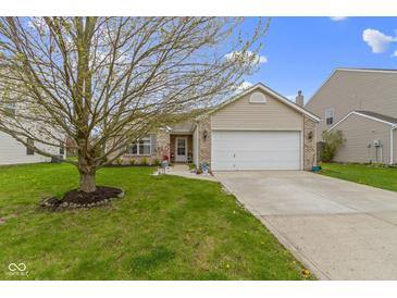 Charming brick home with a two-car garage and inviting front yard with mature tree and vibrant green lawn at 17072 Newberry Ln, Westfield, IN 46074