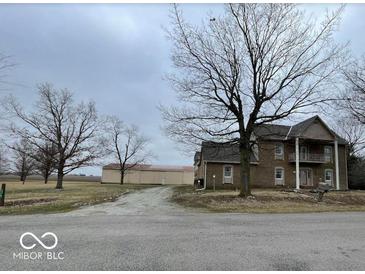 Traditional two-story home featuring a covered porch, dormer windows, and an expansive front yard at 2365 E 850 N, Lebanon, IN 46052