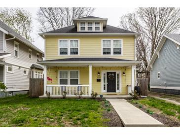 Charming two-story home with a welcoming front porch, black door, and beautiful lawn at 3133 Ruckle St, Indianapolis, IN 46205