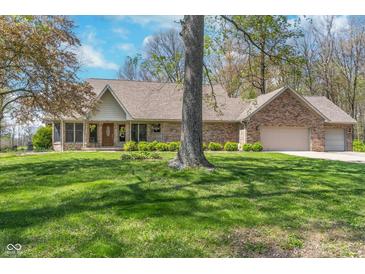 Beautiful brick home with mature landscaping and attached two car garage on a sunny day at 3718 S County Road 101 E, Clayton, IN 46118