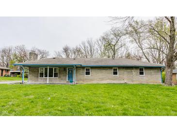 Charming single story home showcasing a stone facade and well-manicured lawn and bright blue trim at 3959 N Grant Ave, Indianapolis, IN 46226