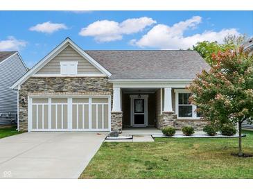 Charming single-Gathering home with a stone facade, neutral siding, manicured lawn, and a two-car garage at 6103 Pebblebrooke Rd, Whitestown, IN 46075