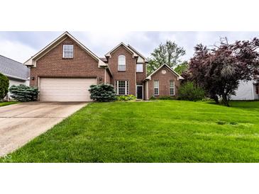 Beautiful two-story brick home featuring an attached garage and a lush green front lawn at 7131 Topp Creek Ct, Indianapolis, IN 46214