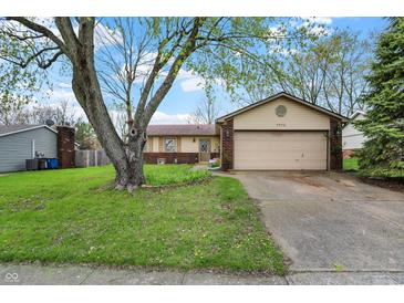 Charming ranch home with a two-car garage and mature tree in the front yard at 7702 Dornock Dr, Indianapolis, IN 46237