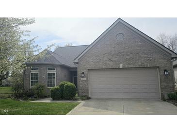 Charming brick home featuring a two-car garage, well-maintained landscaping, and a welcoming front entrance at 13648 Seven Oaks Dr, Fishers, IN 46038