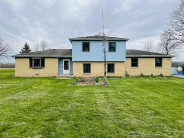 Charming two-story home with a well-maintained lawn and light blue siding, offering a welcoming curb appeal at 1387 W Furry Rd, Fountaintown, IN 46130