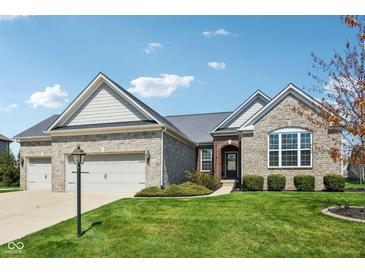 Charming single-story home with stone facade, three-car garage, and well-manicured front lawn at 14814 Edgebrook Dr, Fishers, IN 46040