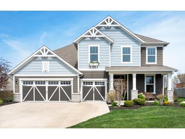 Charming two-story home with blue siding, a three-car garage, and beautifully landscaped front yard at 18488 Jaden Dr, Westfield, IN 46062
