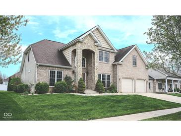 Charming two-story brick home with a stone entrance, well-kept lawn, and attached two-car garage at 3389 Grant Ct, Columbus, IN 47203