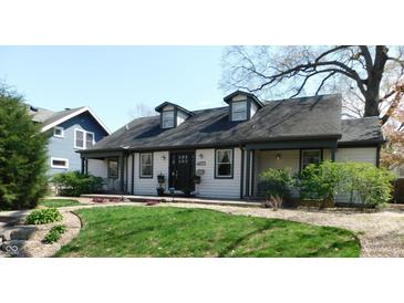 Charming home featuring a well-manicured lawn and inviting facade with dormer windows and a covered porch at 4815 Carrollton Ave, Indianapolis, IN 46205