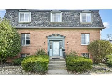 Charming brick facade of a two-story condominium with a well-manicured front entrance and dormer windows at 6017 E 52Nd Pl, Indianapolis, IN 46226