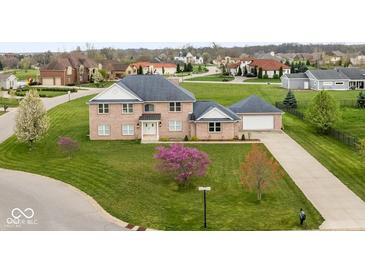 Beautiful brick home features a lush green lawn and mature trees at 6519 Rothchild Blvd, Indianapolis, IN 46278