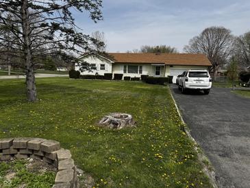 Charming single-story home featuring a well-manicured front yard and paved driveway at 712 E Mckenzie Rd, Greenfield, IN 46140