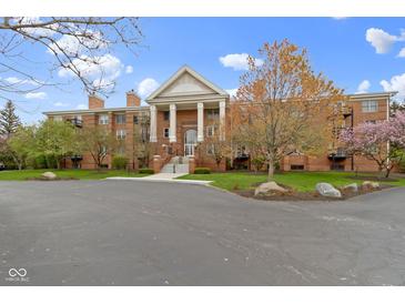 Brick building with a stately entrance featuring prominent columns and well-maintained landscaping at 8651 Jaffa Court East Dr # 18, Indianapolis, IN 46260
