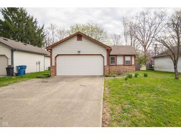 Charming home featuring a well-maintained lawn, neutral siding, brick accents, and an attached two-car garage at 9143 Warwick Rd, Indianapolis, IN 46240