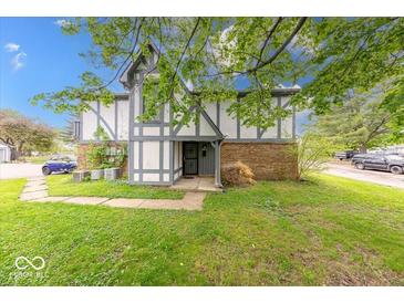 Charming townhome featuring a well-maintained lawn and classic Tudor-style architecture at 9855 Haven Ct, Indianapolis, IN 46235