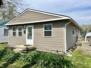 Charming home featuring vinyl siding, a well-manicured lawn, and blooming plants adding curb appeal at 1136 Lawrence Ave, Indianapolis, IN 46227