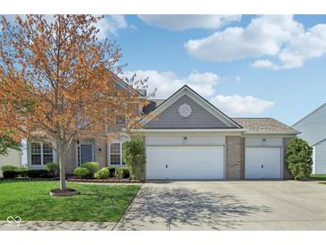 Charming two-story home with three-car garage and well-maintained front yard at 14323 Chariots Whisper Dr, Carmel, IN 46074