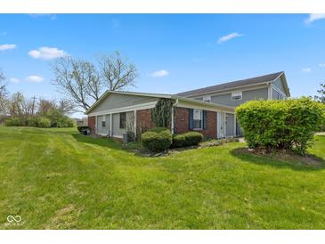 Charming home featuring a well-maintained lawn and lush landscaping on a sunny day at 4464 Four Seasons Cir, Indianapolis, IN 46226
