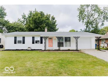 Charming single-story home featuring a white exterior, black shutters, a pink door, and a well-maintained front lawn at , Indianapolis, IN 46226