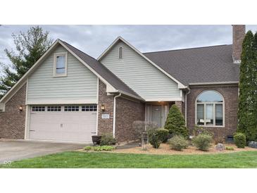 Charming brick home with a two-car garage, arched window, and well-maintained lawn at 5573 Royal Troon Way, Avon, IN 46123