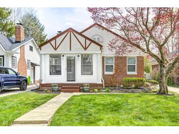 Charming home with a well-manicured lawn, brick accents, and beautiful blossoming tree at 5933 Guilford Ave, Indianapolis, IN 46220