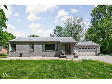 Charming single-story brick home featuring an attached two-car garage and a well-manicured front lawn at 6223 N Parker Ave, Indianapolis, IN 46220