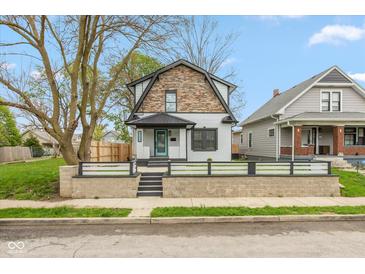 Charming two-story home featuring stone accents, a modern black roof, and a well-kept front yard at 625 N Temple Ave, Indianapolis, IN 46201
