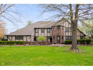 Charming Tudor-style home with a well-manicured lawn and mature landscaping at 1122 Mill Run Dr, Noblesville, IN 46062