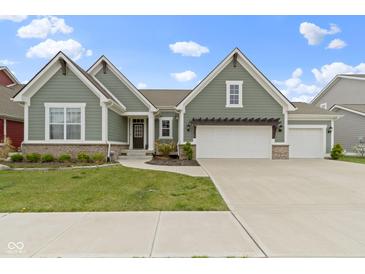 Charming two-story home featuring a three-car garage, craftsman style architecture, and a beautifully landscaped front yard at 1747 Wellpark Dr, Westfield, IN 46074