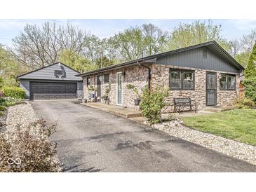 Charming stone home with detached garage, long driveway, and well-maintained landscaping at 1850 Cruft St, Indianapolis, IN 46203
