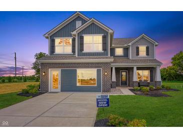 Charming two-story home boasts a brick-accented facade, blue siding, and an inviting covered entry at 187 Luna Pl, Shelbyville, IN 46176