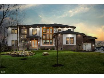 Stunning two-story home at twilight with a meticulously maintained lawn, modern windows, and inviting exterior lighting at 4292 Alderborough Way, Zionsville, IN 46077