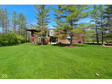 Stunning front exterior featuring a modern design and lush green lawn in a wooded area at 5528 State Road 144, Greenwood, IN 46143