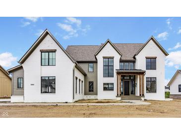 New construction home boasts painted brick, black trim windows and gabled roof against a cloudy blue sky at 8082 Abington Way, Zionsville, IN 46077