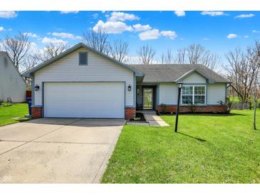 Charming single-story home featuring an attached garage, well-maintained lawn, and appealing curb appeal at 8110 Madrone Ct, Indianapolis, IN 46236