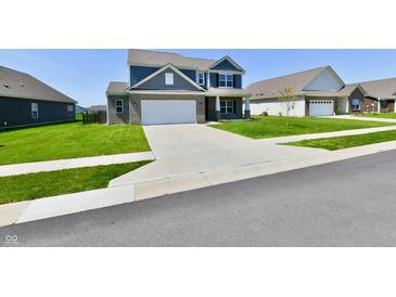 Charming two-story home with a well-manicured lawn and long concrete driveway at 8163 Dewberry Ln, Pendleton, IN 46064