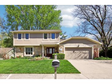 Charming two-story home with a manicured lawn, stone accents, and an attached two-car garage at 8332 Tanager Ln, Indianapolis, IN 46256