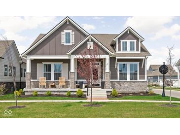 Charming two-story home with stone accents, inviting front porch, and manicured lawn at 1230 Amberley Way, Westfield, IN 46074