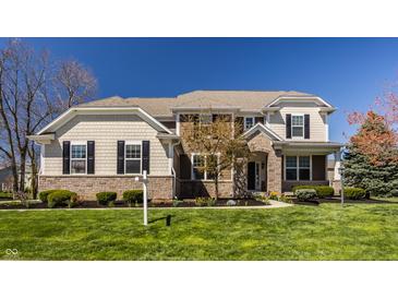 Beautiful two-story home with stone accents and manicured lawn on a clear day at 16016 Viking Lair Rd, Westfield, IN 46074